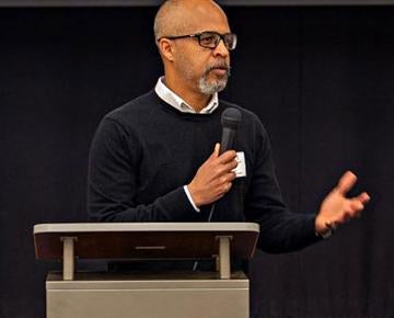 A speaker presents from a podium. 