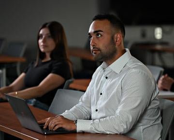 Two law students watch a presentation.